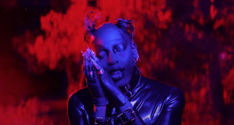 Still from Yves Tumor’s Jackie video, lit in red and violet